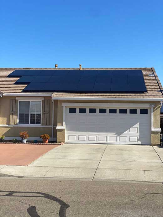 Suburban home with rooftop solar panel array and two-car garage