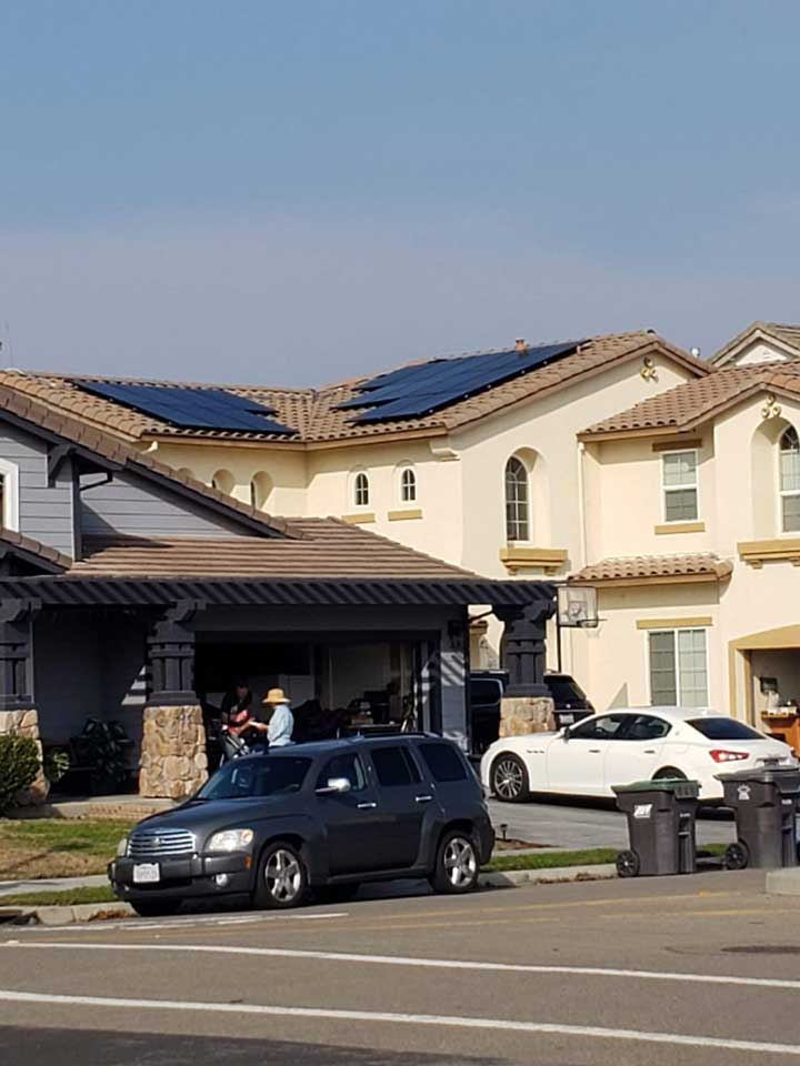 Luxury residential home with solar panel installation on decorative tile roof